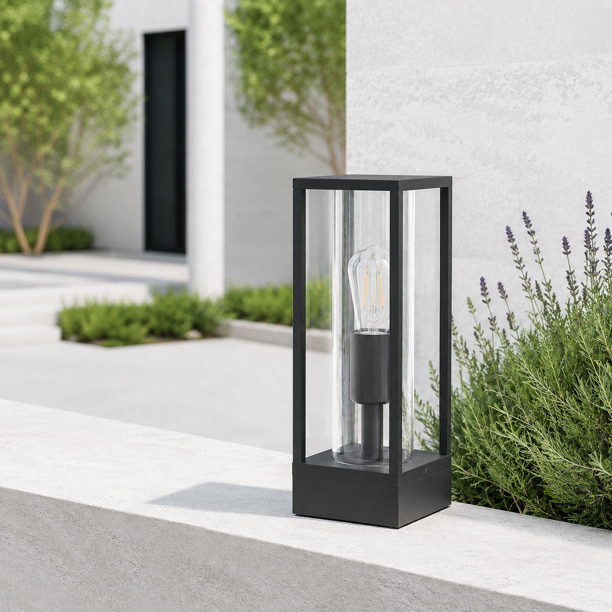 Ted black outdoor post lantern on a white rendered wall with lavender in daylight