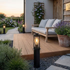 Lucia 40cm black bollard light on decking beside an outdoor sofa and lavender