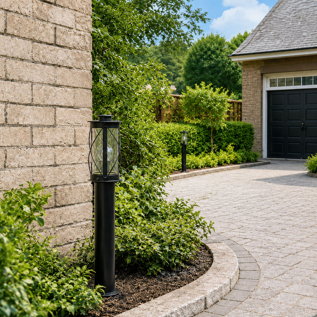 Lucia black rustic bollard post light beside a garage driveway in daylight