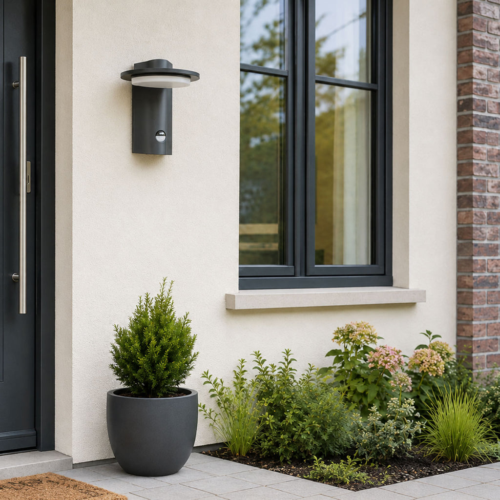Mayson dark grey sensor outdoor wall light on a white house wall beside a window in daylight