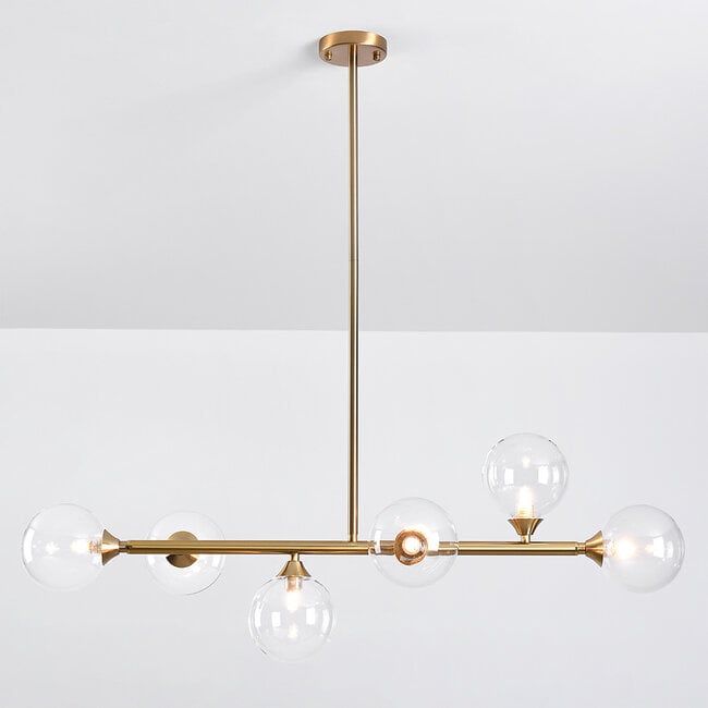 Calla gold and glass pendant light installed above dining table in modern interior